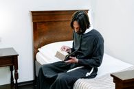 Man Reading a Bible on the Bed