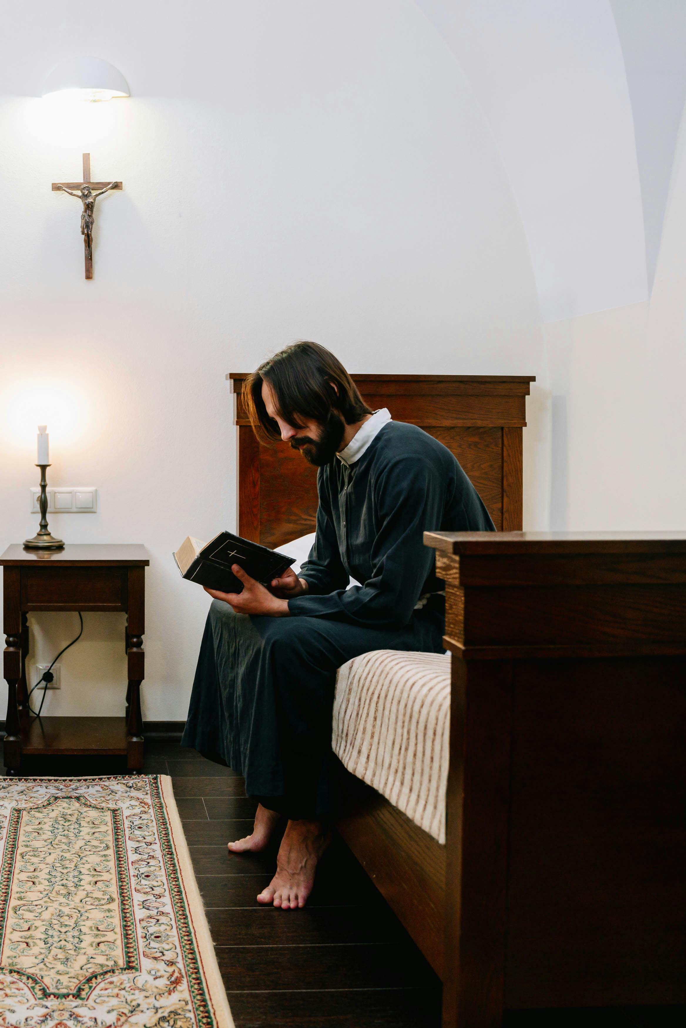 man reading a bible while sitting