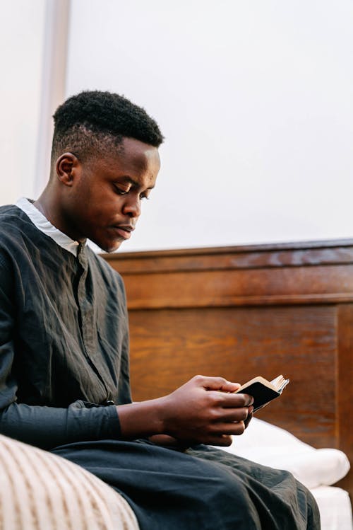 Man Wearing Black Soutane Holding a Bible