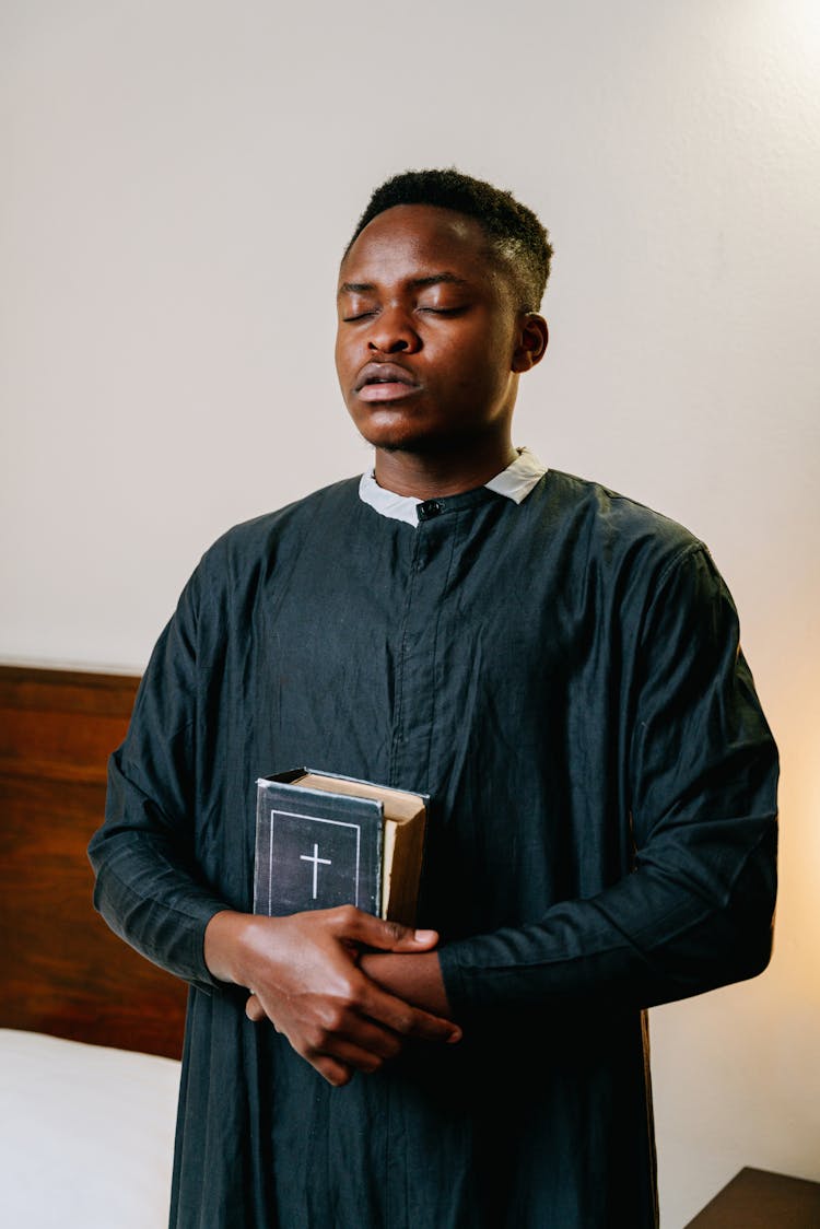 Man In Black Dress Holding A Bible