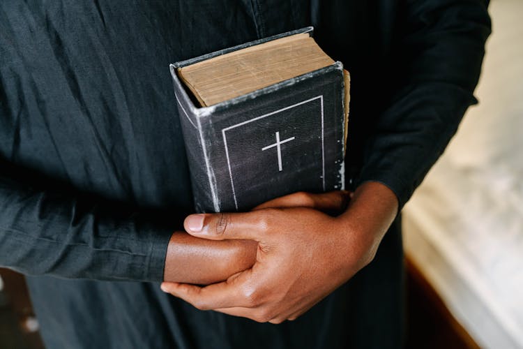 Person Embracing A Bible