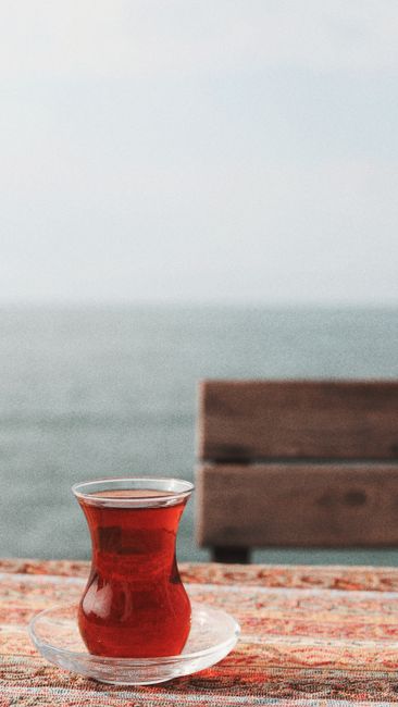 A tranquil scene of a glass of tea by the sea, perfect for relaxation themes.