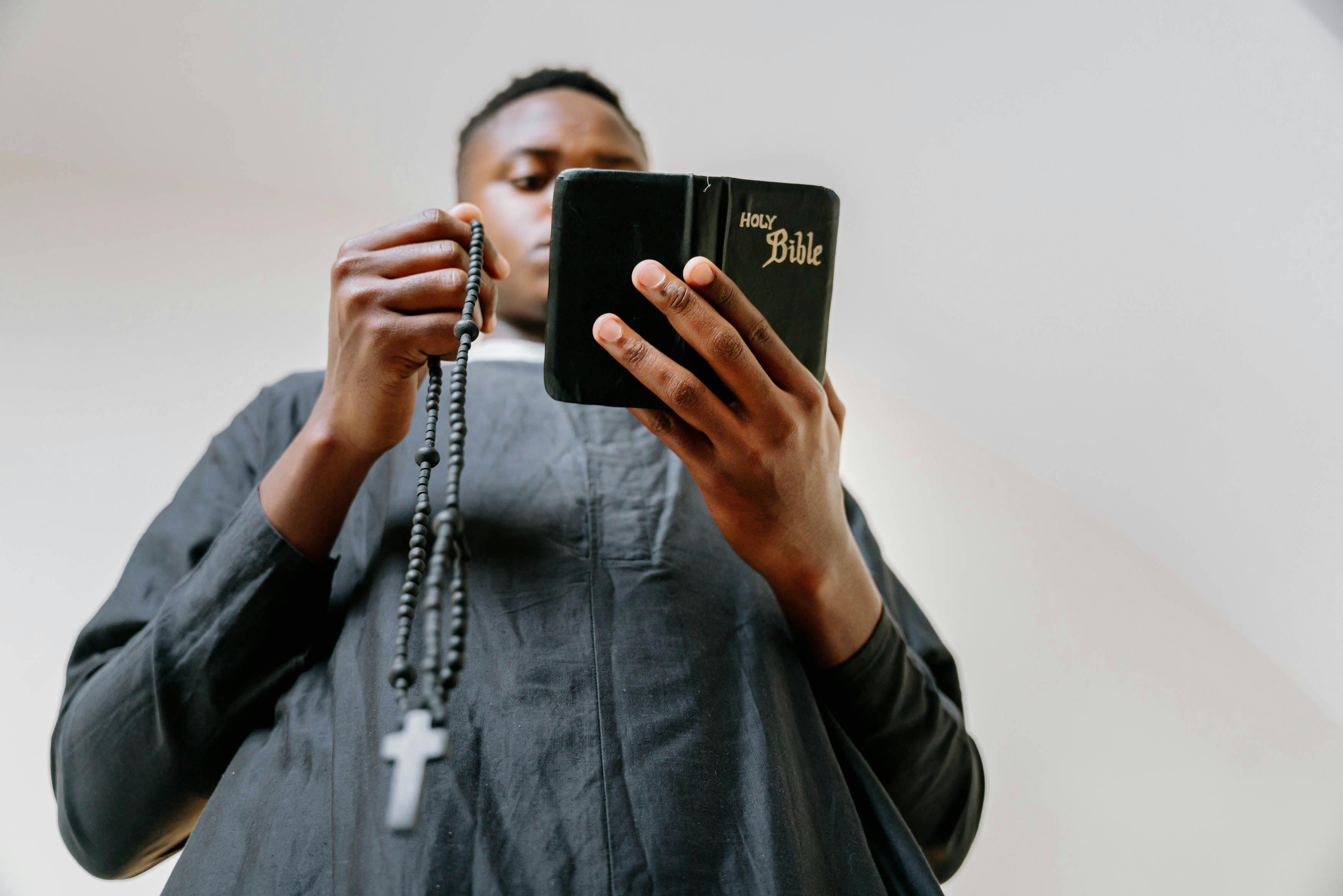 man praying while reading a bible