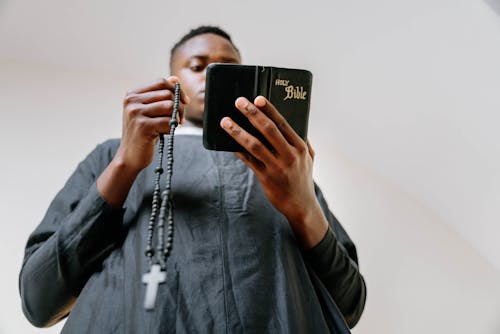 Free Man Praying While Reading a Bible Stock Photo