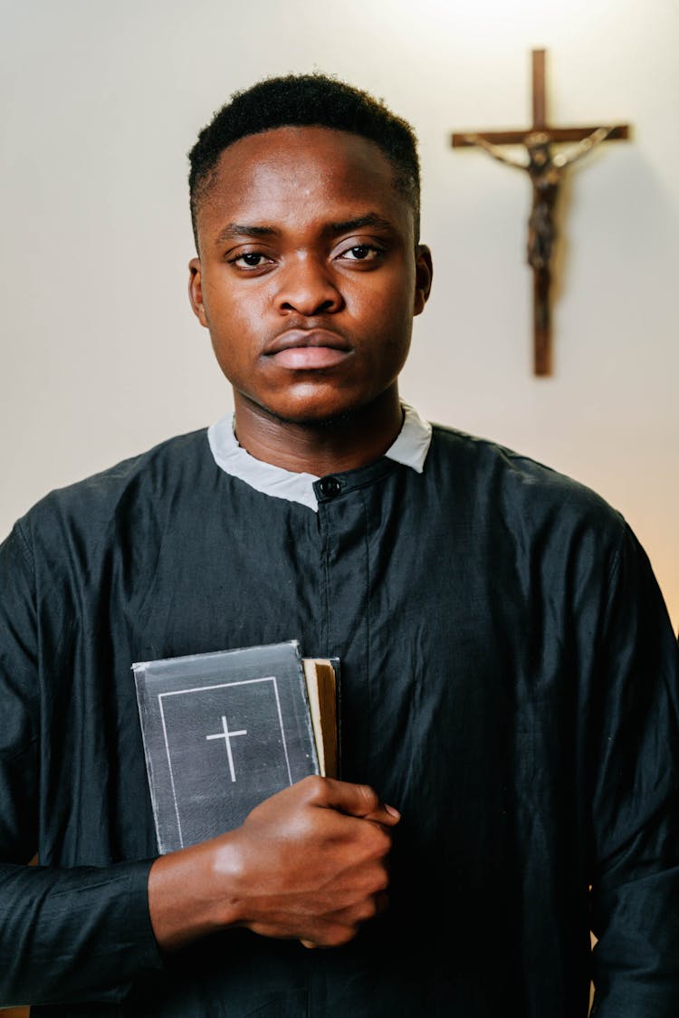 Man In Black Dress Holding A Bible