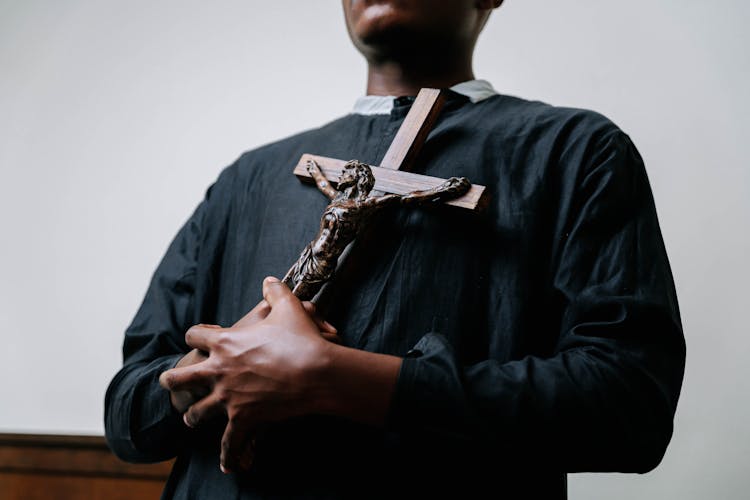 A Man Holding A Crucifix