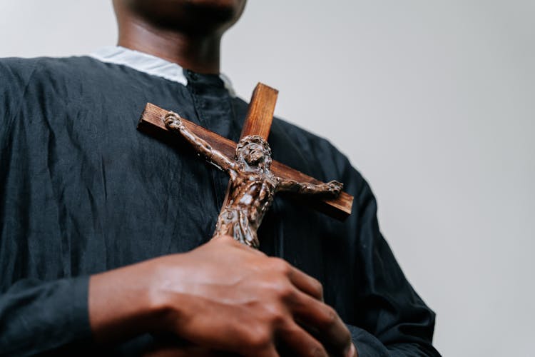 Man Wearing Cassock Holding A Cross