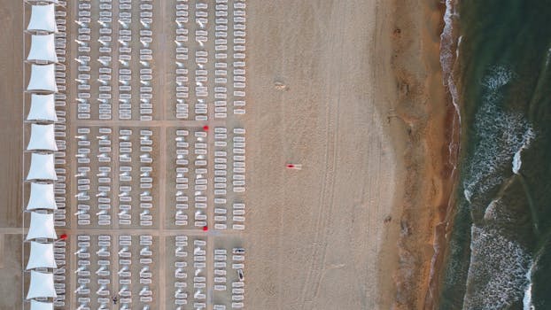 Aerial drone shot of organized empty beach chairs and coastline in Krasnodar Krai, Russia.