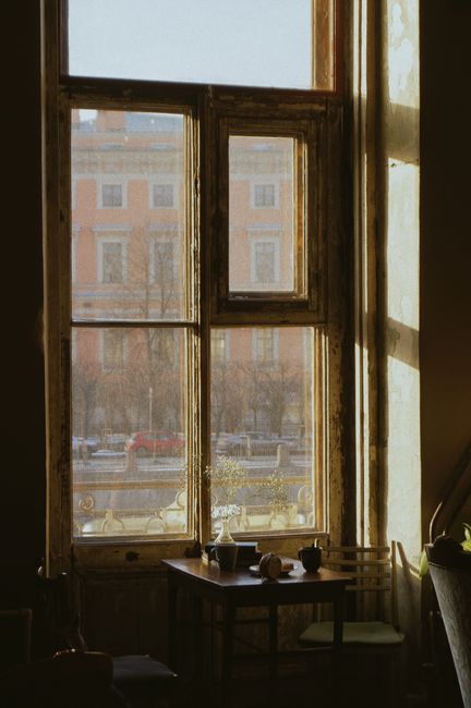 Cozy vintage café interior with sunlit window and rustic table setting.