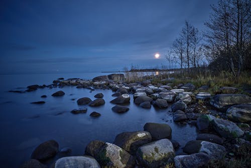 A Rocks Near the Body of Water during Night Time