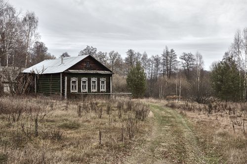 Free Charming rustic wooden house surrounded by natural countryside scenery and autumn trees. Stock Photo