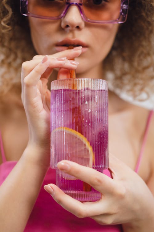 A Close-up Shot of a Woman Drinking Cocktail