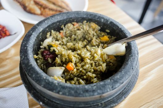 Tasty vegetable rice served hot in a traditional stone pot, perfect for food photography.