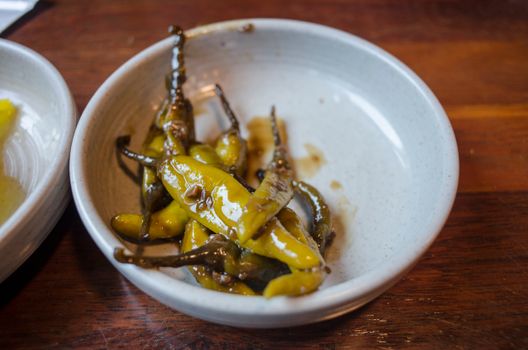 Oily Green Chili Peppers on a White Bowl