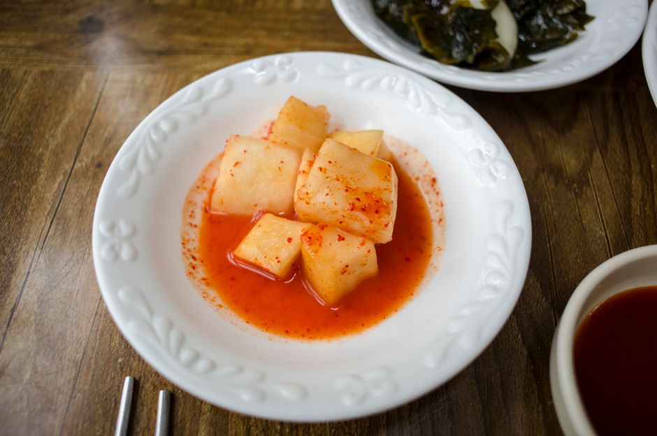 赤唐辛子ソースを添えたスパイシーな韓国の大根キムチが、鮮やかで伝統的な風味を引き立てます。