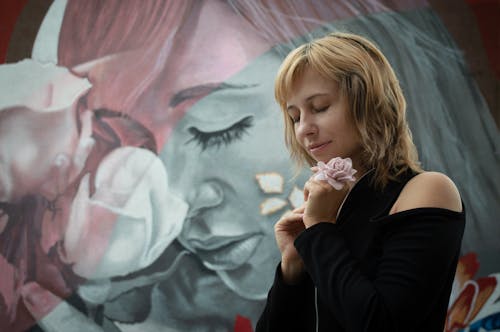 Woman in Black Long Sleeves Standing Near the Wall Painting 