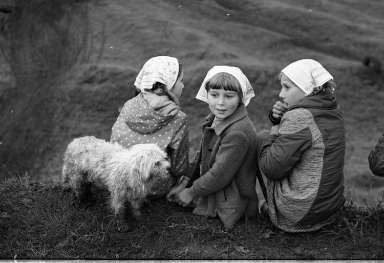 Grayscale Photo Of Children Sitting On Grass With A Dog