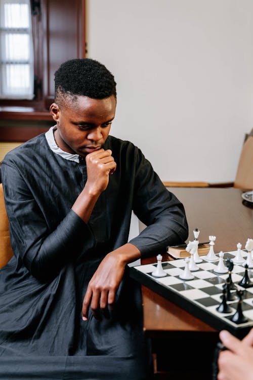 Man Wearing a Cassock Playing Chess