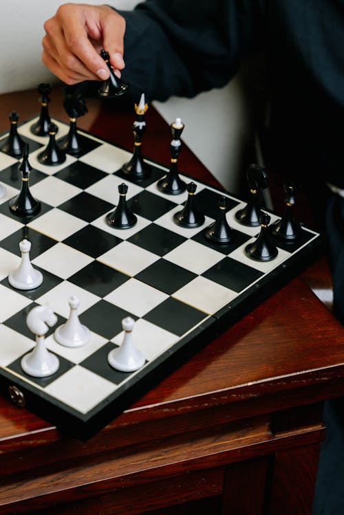 Black and White Chess Board on Wooden Table 