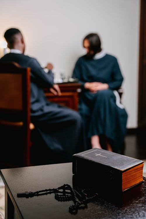 Selective Focus of Rosary and Bible on the Wooden Table