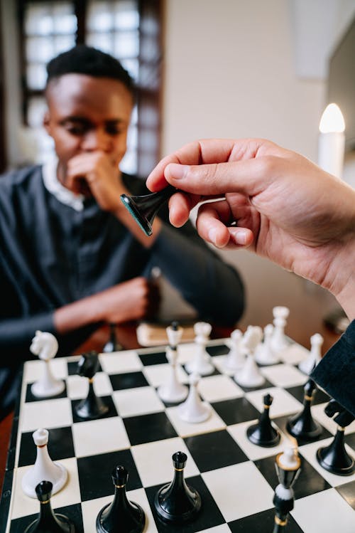 Free A Man and a Person Playing Chess Together Stock Photo