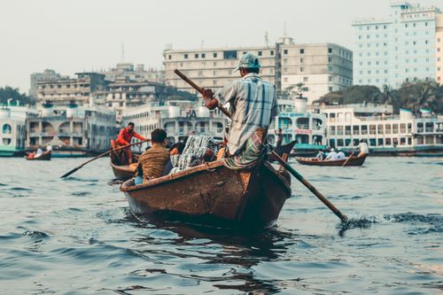 Free A view of boatmen navigating the bustling waters of Buriganga River in Dhaka, Bangladesh. Stock Photo