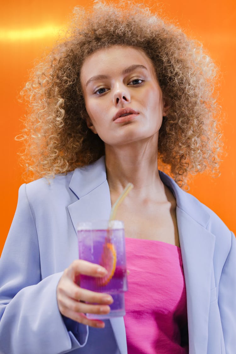 Portrait Of A Young Woman In Lilac Blazer Holding A Refreshing Drinks