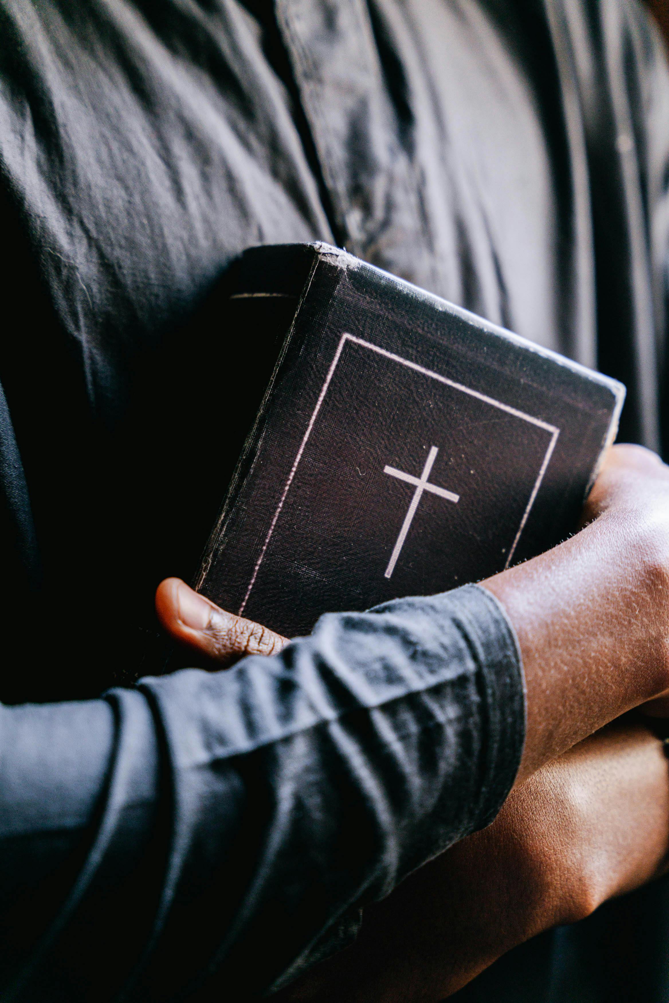 Persons Hugging A Bible · Free Stock Photo