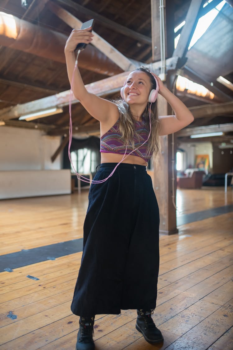 Woman Wearing A Headset Holding A Smartphone