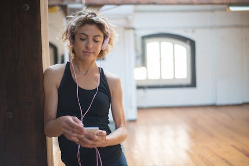 Woman Leaning on a Column While Using a Cellphone