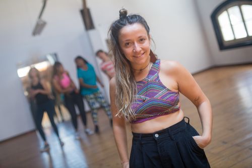 Free Smiling woman poses in vibrant top at a dance studio in Portugal. Stock Photo