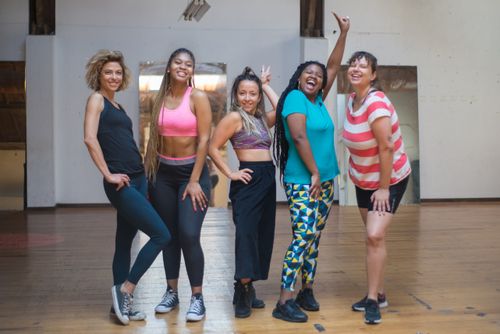 Free Five diverse women joyfully pose in a dance studio, promoting fitness and friendship. Stock Photo