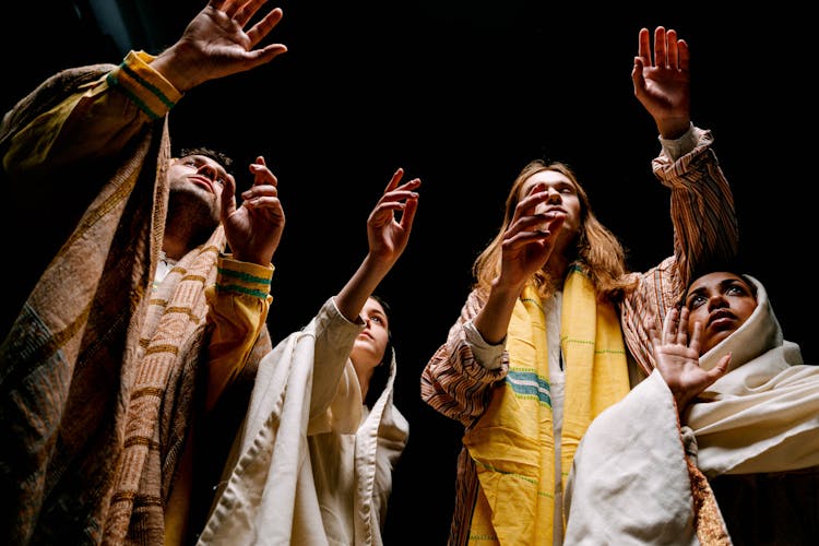 Low Angle Shot Of Actors In Costumes And Headscarves Performing On Stage 