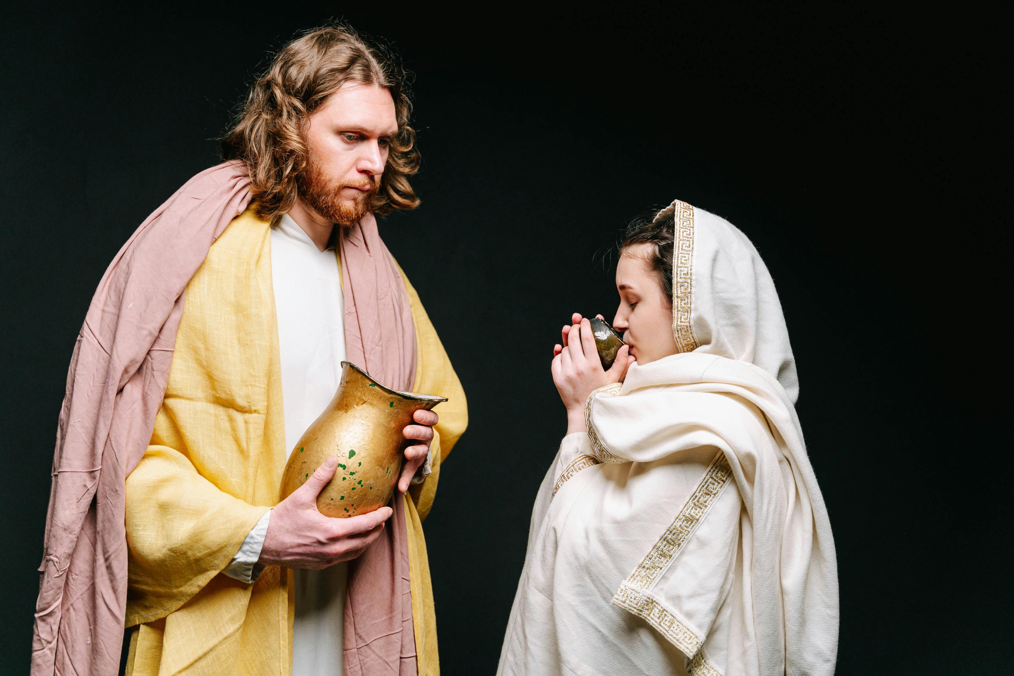 Free Man and woman in traditional garments engaging in a religious ceremony. Stock Photo