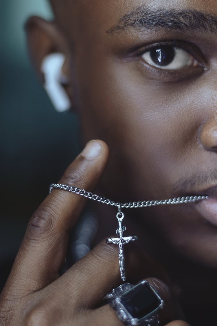 Young Boy Holding A Crucifix Necklace