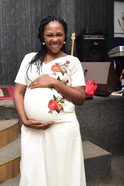 Pregnant Woman Holding Her Belly and Smiling 