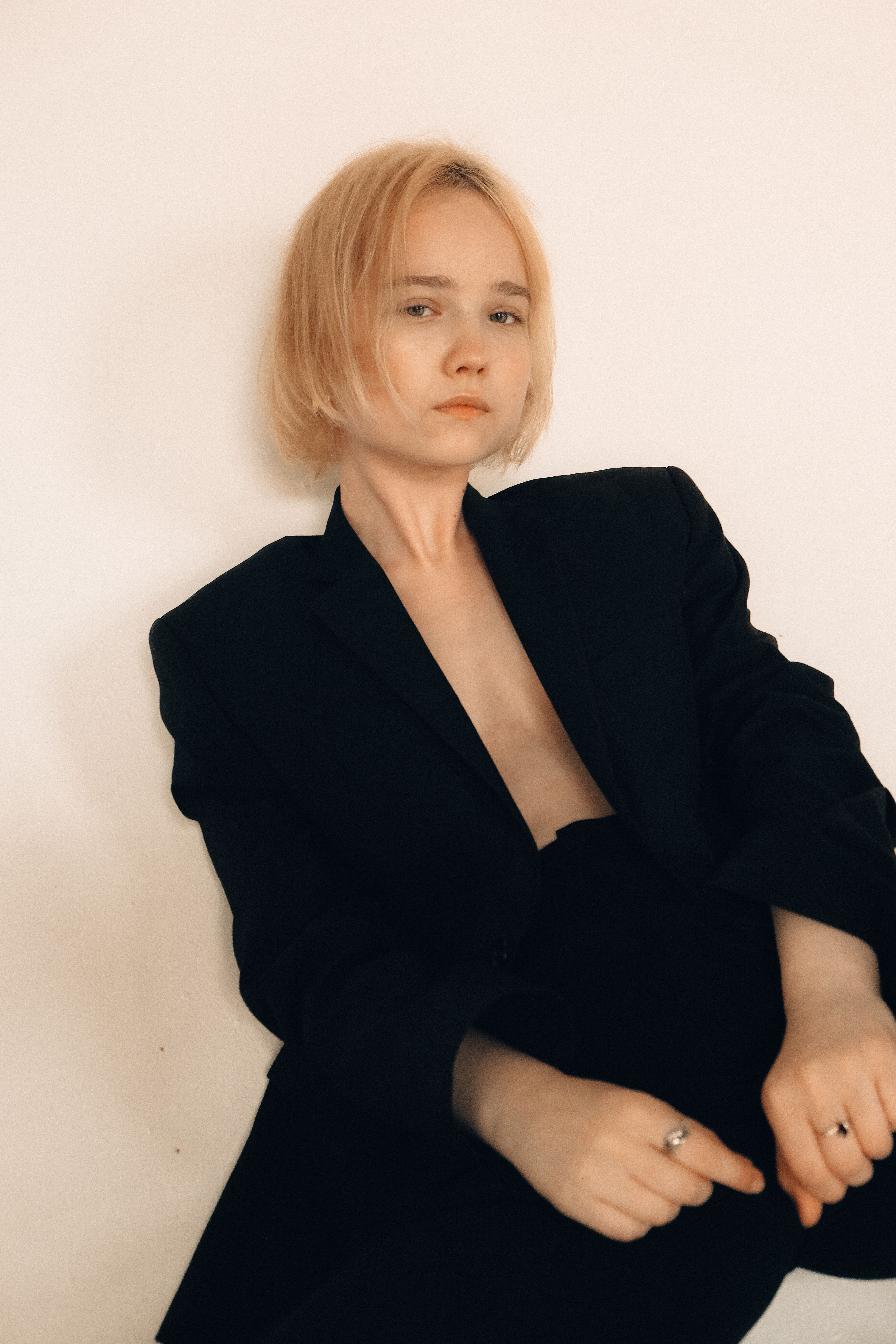 Portrait of a woman in a black blazer against a neutral background.