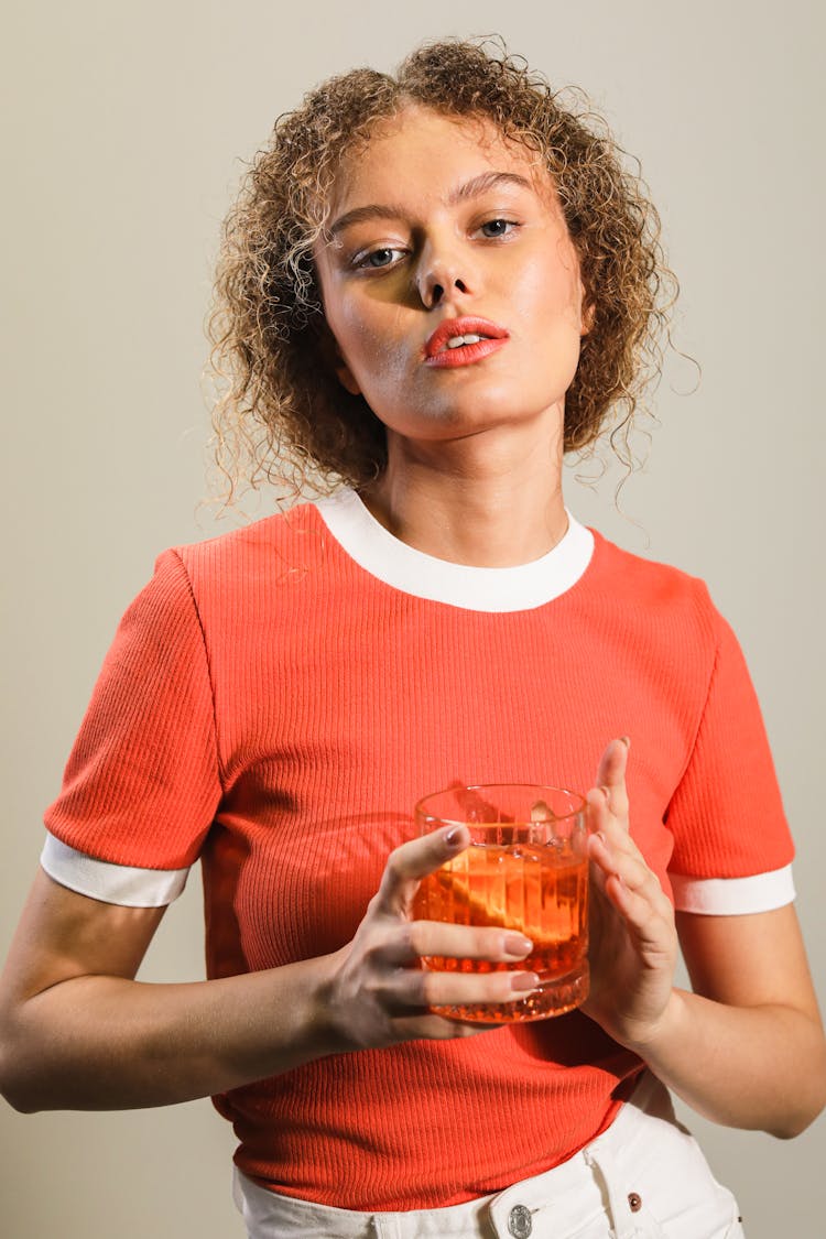 A Woman Holding A Negroni Cocktail