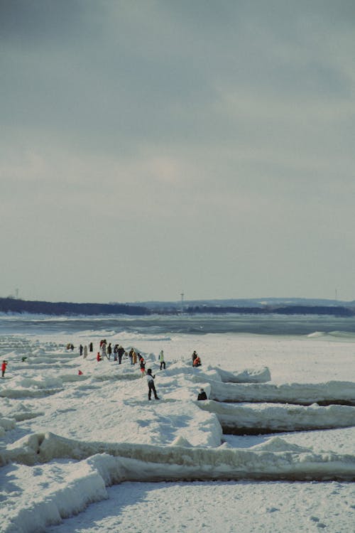 A Group of People Standing on Snow Covered Ground 