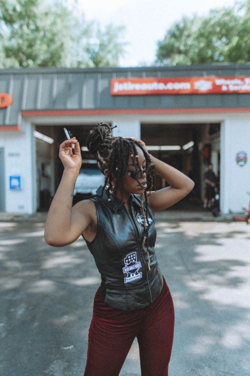 Free Stylish woman with braided hair and sunglasses posing confidently outdoors. Stock Photo