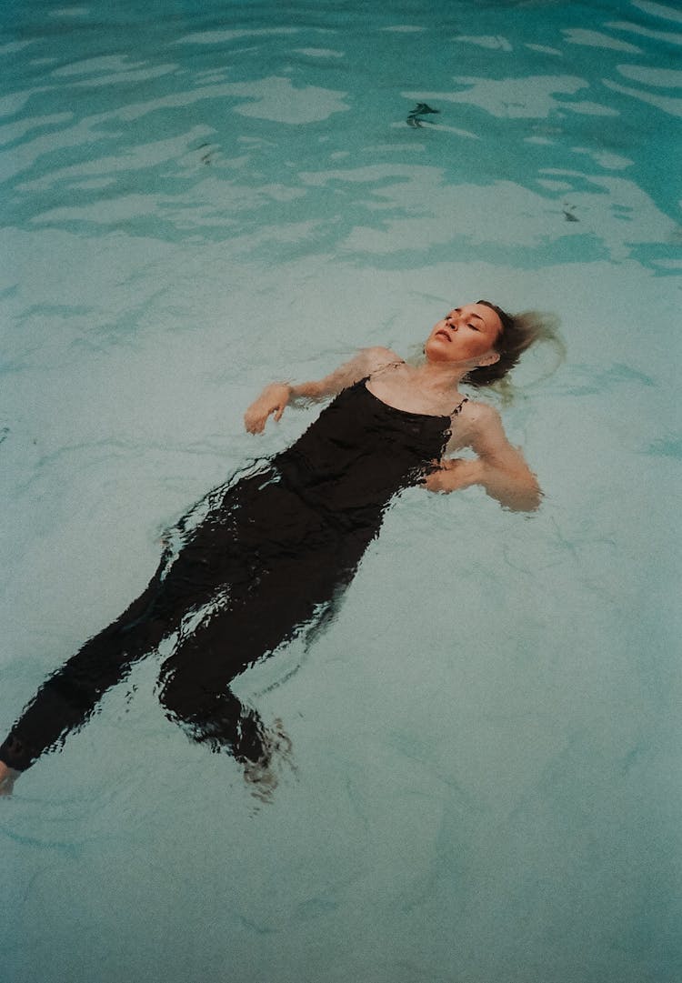 Woman In Black Tank Top Floating On The Water