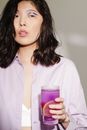 Woman in White Shirt Holding Purple Drinking Glass