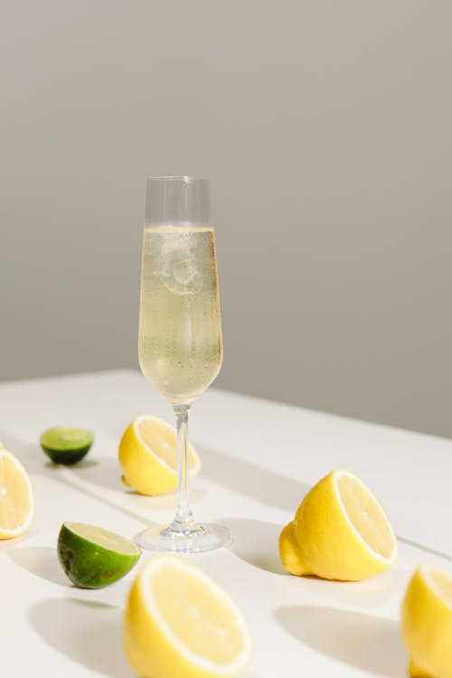 Foto profissional grátis de champagne, limões, superfície branca