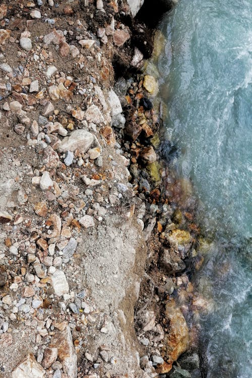 Stones on Dirt Ground Near Body of Water