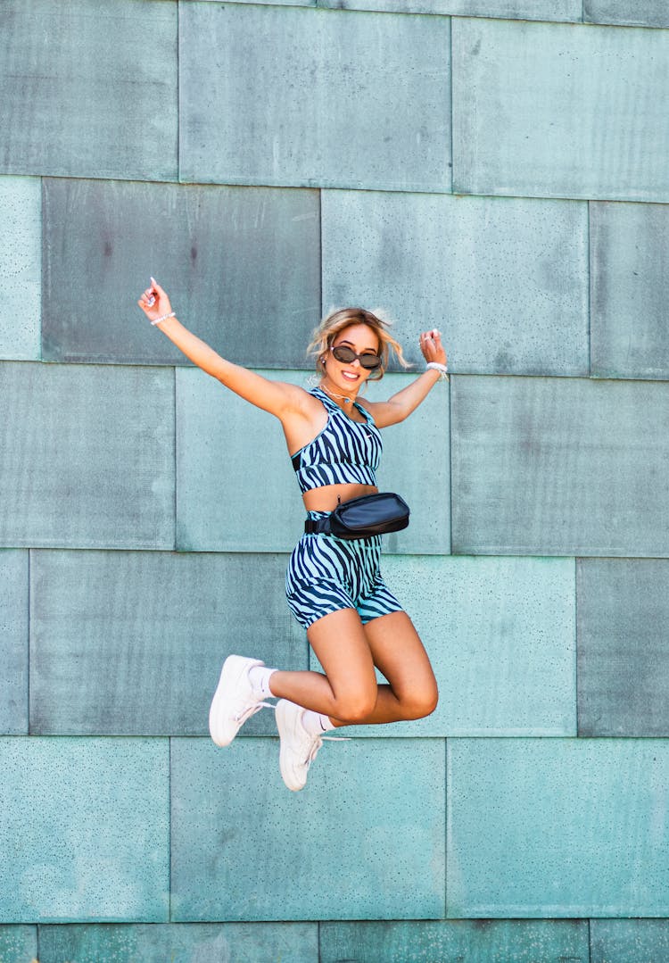 A Beautiful Woman Jumping Near The Wall