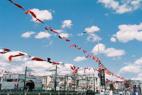 Red Buntings Hanging on Streetlights Under a Blue Sky With White Clouds