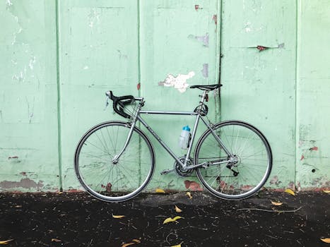 A sleek road bike with a water bottle leans against a pastel green wall, showcasing urban cycling culture in Istanbul.