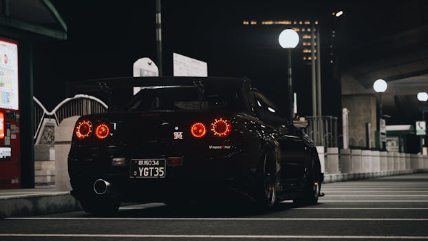 A sleek sports car parked on an urban street at night, illuminated by streetlights.