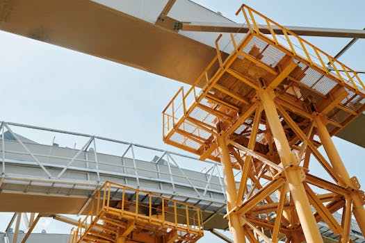 Yellow scaffolding structure with metal framework against clear sky.