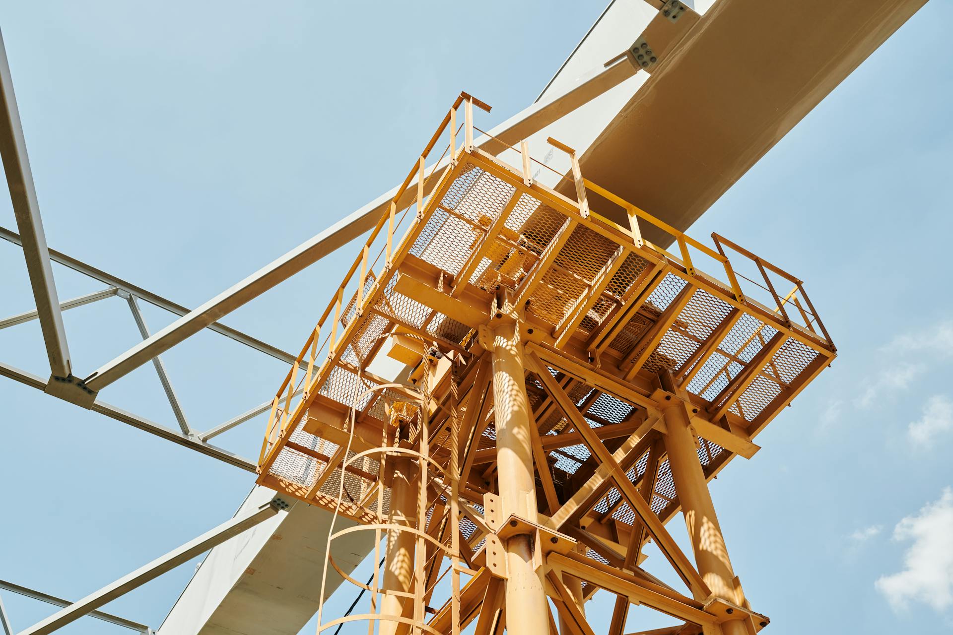 Low angle view of a metal construction structure against a blue sky, highlighting engineering and architecture.